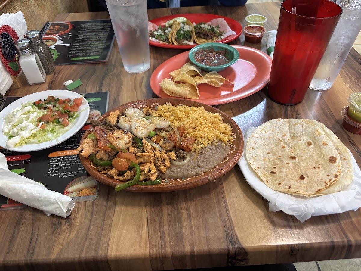 Sizzling shrimp fajitas with Mexican rice, refried beans, and warm tortillas at Guacamole Restaurant